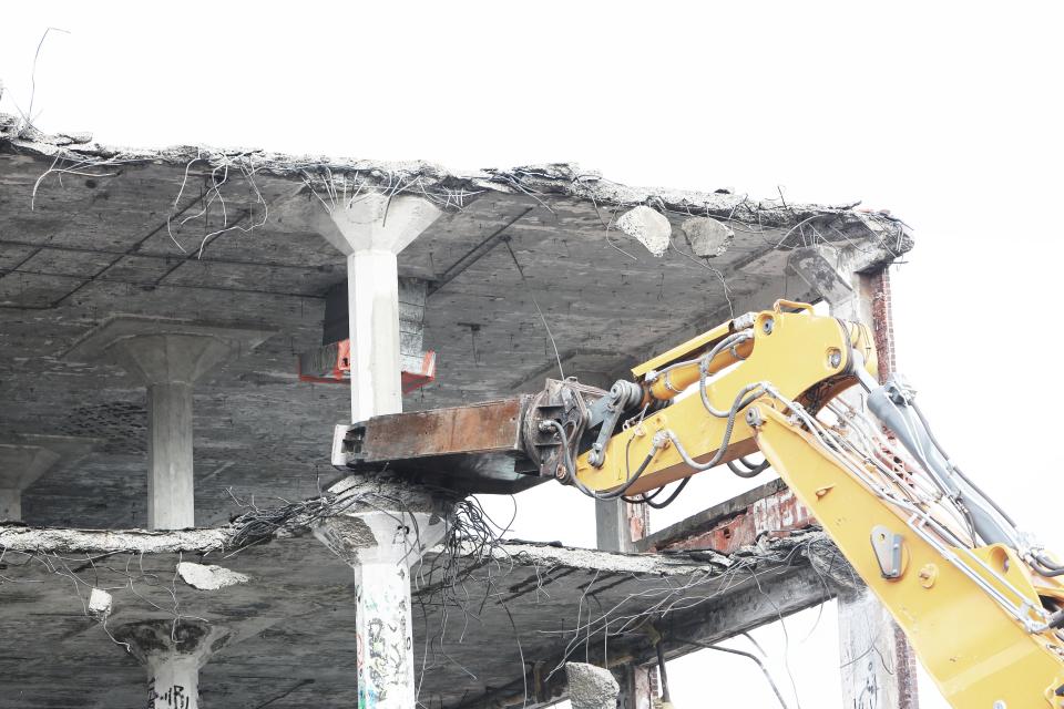 Bagger arbeitet an einer Betonwand